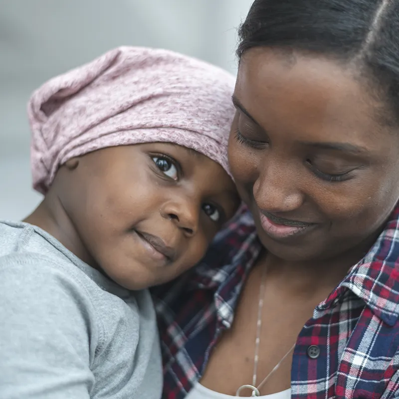Mother comforting child with Cancer