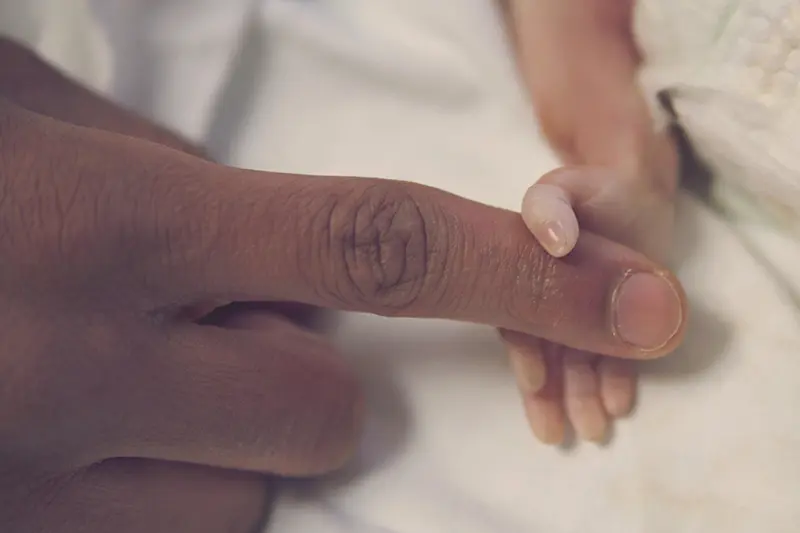 Terminal prenatal baby holding mother's finger
